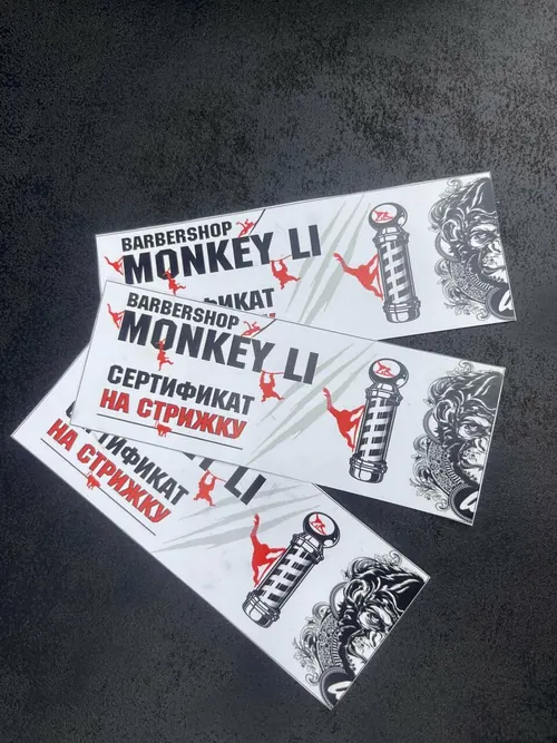 Подарочные сертификаты Monkey Li на стрижку: белые карточки с надписью «Barbershop Monkey Li», красными силуэтами обезьян, барберским столбом и гравюрой обезьяны