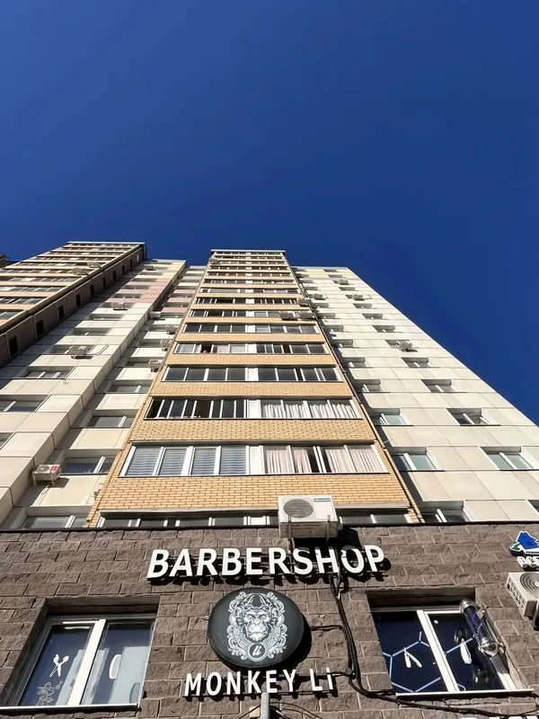 Вывеска BARBERSHOP MONKEY Li с логотипом на фасаде дома